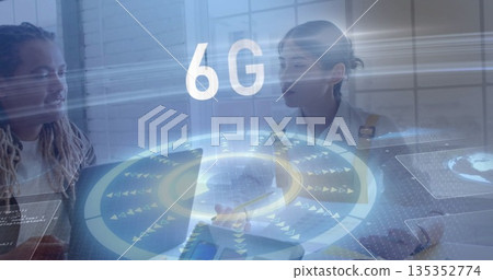 Collaborating professionals inputting on laptop and tablet in office with holographic 6G overlay Collaborating professionals inputting on laptop and tablet in office with holographic 6G overlay 135352774
