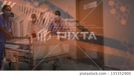 Wheeling masked team pushing gurney with IV pole down hospital corridor, orange digital overlays Wheeling masked team pushing gurney with IV pole down hospital corridor, orange digital overlays 135352900
