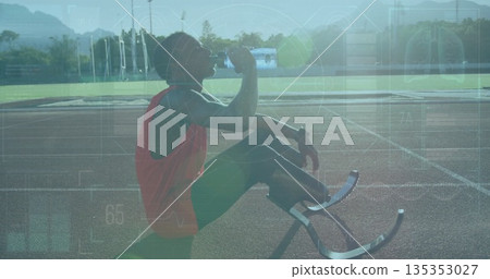 Kneeling teenage Paralympic runner drinking from water bottle on red track, with blades, copy space Kneeling teenage Paralympic runner drinking from water bottle on red track, with blades, copy space 135353027