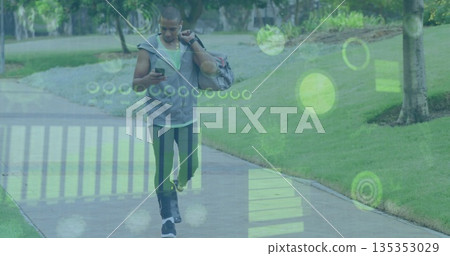 Walking athletic man glancing at smartphone on park path, with duffle bag, headphones and HUD Walking athletic man glancing at smartphone on park path, with duffle bag, headphones and HUD 135353029