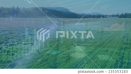 Extending center pivot irrigation arm sprinkling green crop rows at farm field, with farm building 135353183