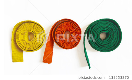 Three martial arts belts: orange, yellow, and green, isolated on a white background. Suitable for diplomas, posters, and websites about martial arts, aikido, karate, and judo Three martial arts belts: orange, yellow, and green, isolated on a white background. Suitable for diplomas, posters, and websites about martial arts, aikido, karate, and judo 135353270