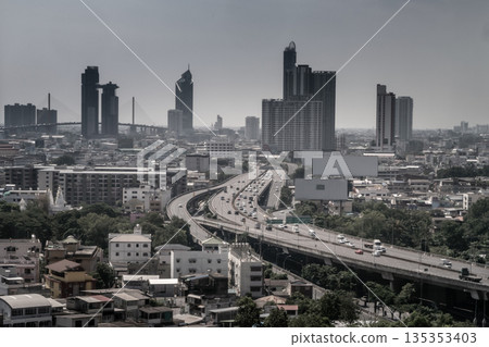 Aerial view of cars driving on highway junctions. Bridge roads with green garden and trees in connection of architecture concept. Top view. Urban city. 135353403