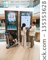 Visitors at Changi Airport interacting with digital directory in modern architecture setting 135353628