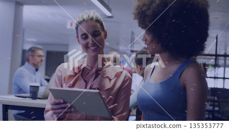 Tapping tablet White woman in pink blouse collaborating at open-plan office desks, copy space 135353777