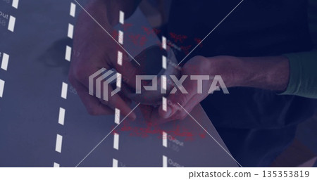 Holding smartphone in green-sleeved hands projecting coded text onto smooth tabletop at work desk 135353819