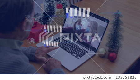 Facing senior man watching women wearing masks chatting online in dining area with gift boxes 135353823