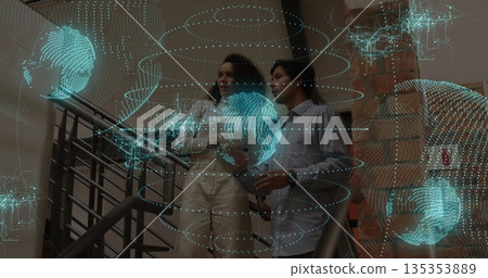 Business professionals examining holographic display on office stairs, with smartphone 135353889