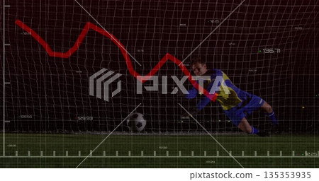 Diving goalkeeper in blue yellow uniform blocking shot on turf, with soccer ball, red graph overlay 135353935