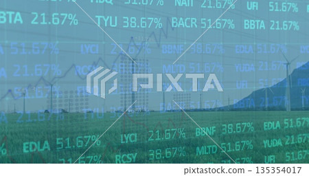 Showing wind turbines rotating over grassy plain toward mountain range, with stock ticker overlay 135354017