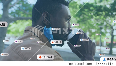 Sipping coffee from cup, man with blue face mask at park bench with floating social icons Sipping coffee from cup, man with blue face mask at park bench with floating social icons 135354112