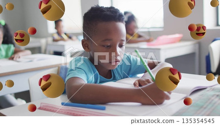 Writing boy wearing T-shirt using green pencil on open notebook at school desk, with ruler pen Writing boy wearing T-shirt using green pencil on open notebook at school desk, with ruler pen 135354545
