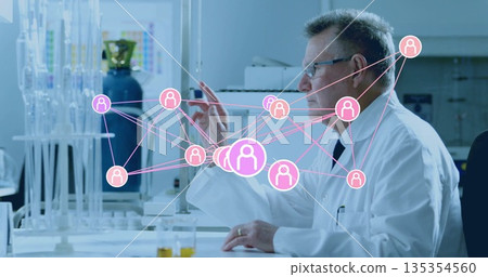 Gesturing researcher wearing lab coat pointing at digital network icons in lab with glassware racks 135354560