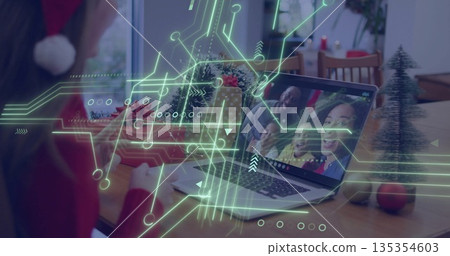 Leaning woman in red sweater and Santa hat using laptop at home dining table, copy space Leaning woman in red sweater and Santa hat using laptop at home dining table, copy space 135354603