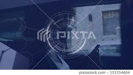 Using smartphone, woman wearing face mask sitting in car backseat, showing interface overlay 135354604