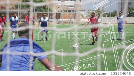 Aiming red-jerseyed striker preparing free-kick at urban soccer field, with soccer ball and netting 135354648