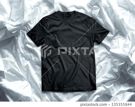 Minimalist Flat Lay of a Blank Black Crew Neck T-shirt on White Crumpled Fabric Background, High-Quality Apparel Mockup Template for Fashion Branding and Custom Logo Presentation. 135355844