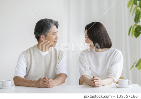 A couple in their 50s smiling and facing each other 135357166