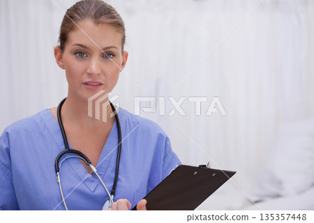 Female medical professional standing with black clipboard in exam room wearing scrubs stethoscope Female medical professional standing with black clipboard in exam room wearing scrubs stethoscope 135357448