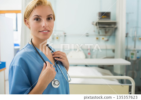 Female nurse standing in hospital holding stethoscope near bed, monitor and gas panel, copy space Female nurse standing in hospital holding stethoscope near bed, monitor and gas panel, copy space 135357623
