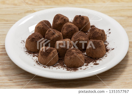 Truffles served on a white plate on a wooden table Truffles served on a white plate on a wooden table 135357767