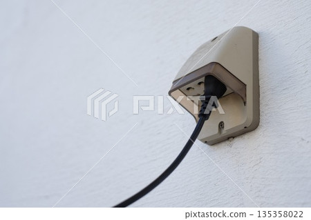 Outdoor outlet installed on a plaster wall 135358022