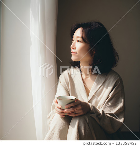一位日本女性一邊喝咖啡一邊思考。一幅靜謐時光與內省的寫照。 135358452