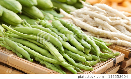 Fresh green beans and white root vegetables arranged in woven bamboo baskets at a market display showcasing natural organic produce. AI Generated 135358604