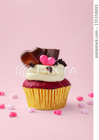 Red velvet cupcake with cream cheese frosting, decorated with heart chocolate on pink background, valentines day and celebrating love concept 135358893