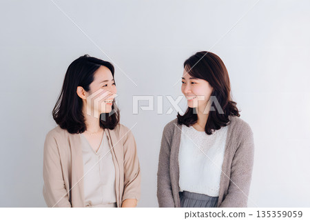 A portrait of a family, mother and daughter facing each other. A portrait of a family, mother and daughter facing each other. 135359059