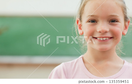 Child girl student standing in front of green chalkboard in classroom with chalk ledge, copy space Child girl student standing in front of green chalkboard in classroom with chalk ledge, copy space 135359451