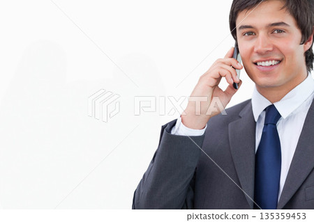 Businessman gray suit blue tie holding smartphone to ear smiling against white backdrop, copy space 135359453