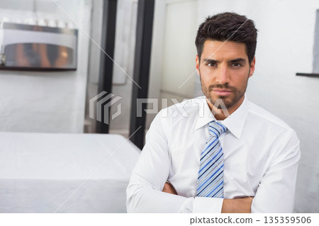 Man sitting at office table in business attire near dispenser and glass partition, copy space Man sitting at office table in business attire near dispenser and glass partition, copy space 135359506