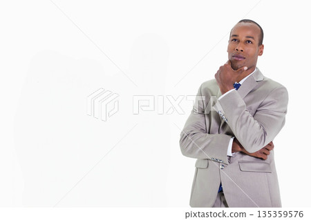 African American man wearing suit and tie standing thoughtfully on white backdrop, copy space African American man wearing suit and tie standing thoughtfully on white backdrop, copy space 135359576