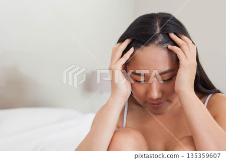 Korean woman sitting on bed pressing temples in dimly lit bedroom with bedside lamp, copy space Korean woman sitting on bed pressing temples in dimly lit bedroom with bedside lamp, copy space 135359607