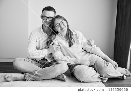 Portrait of father and teenage daughter hugging each other at home. Cute moment of dad and child in glasses showing their love to each other. Lovely spending time with family. Black and white image. 135359666