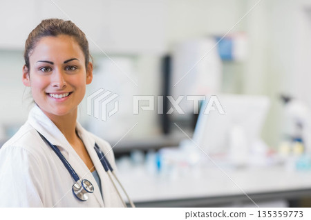 female doctor wearing white lab coat with stethoscope reviewing monitor in lab, copy space female doctor wearing white lab coat with stethoscope reviewing monitor in lab, copy space 135359773