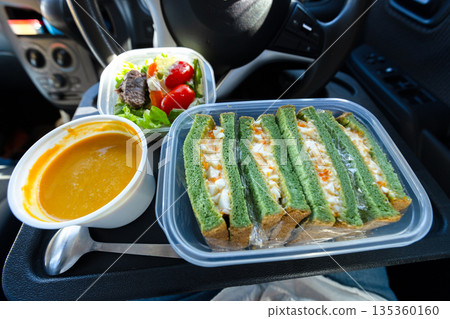Enjoying lunch in the car: egg sandwich, pumpkin soup, and salad Enjoying lunch in the car: egg sandwich, pumpkin soup, and salad 135360160