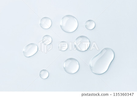 Transparent drops of cosmetics on a gray background 135360347