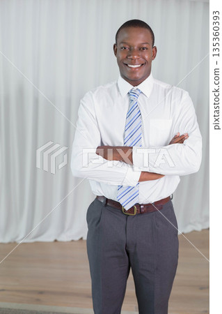 African American man smiling and standing in studio showing striped tie and leather belt African American man smiling and standing in studio showing striped tie and leather belt 135360393