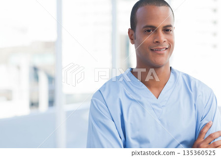 African American man in blue scrubs standing on hospital balcony overlooking skyline, copy space African American man in blue scrubs standing on hospital balcony overlooking skyline, copy space 135360525