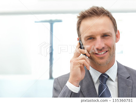 Businessman wearing business attire talking on phone at office window with desk lamp, copy space 135360781
