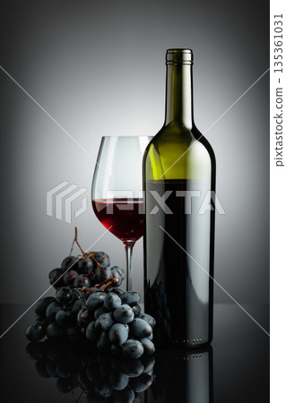 Red wine and juicy blue grapes. 135361031