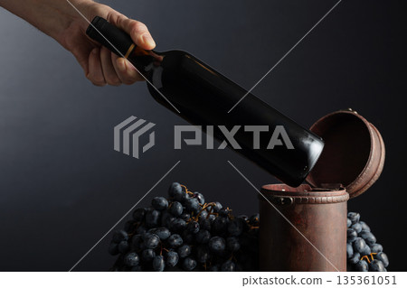 Sommelier places a bottle of red wine in an old wooden box. Sommelier places a bottle of red wine in an old wooden box. 135361051