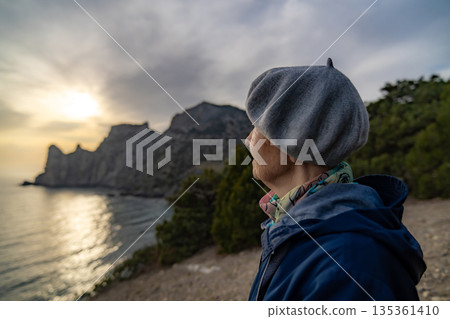 Senior woman nature view contemplating landscape mountains sunset ocean Senior woman nature view contemplating landscape mountains sunset ocean 135361410