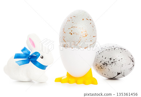 Decorative eggs and a bunny sit on a white background during the spring season Decorative eggs and a bunny sit on a white background during the spring season 135361456