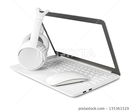 White laptop with headphones and mouse placed on top by the screen White laptop with headphones and mouse placed on top by the screen 135361529