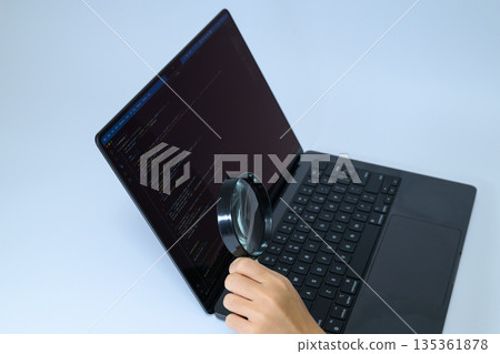 Checking the PC's program code with a magnifying glass Checking the PC's program code with a magnifying glass 135361878