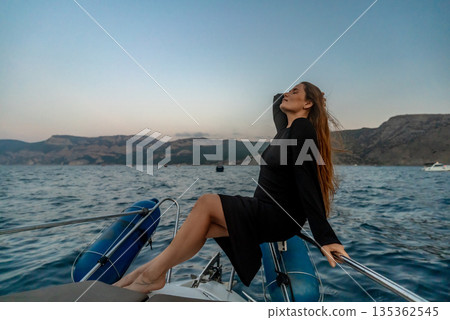 Woman yacht travel, peaceful female enjoying an ocean cruise at sunset with clear copy space. Woman yacht travel, peaceful female enjoying an ocean cruise at sunset with clear copy space. 135362545