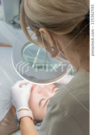 Microneedling, Skincare Clinic, Facial Treatment: Professional performs microneedling treatment on a client's face. Microneedling, Skincare Clinic, Facial Treatment: Professional performs microneedling treatment on a client's face. 135362593